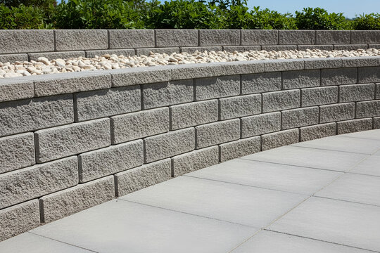 Modern retaining wall with decorative stone and pavers in an outdoor setting