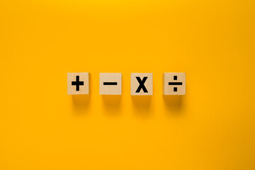 basic mathematic operation symbol on wooden blocks isolated on yellow background
