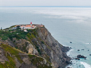 Scenic Aerial View of Cabo da Roca Lighthouse on Rugged Cliffs Overlooking the Atlantic Ocean in Sintra, Portugal