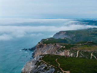 Aerial View of Cabo da Roca's Dramatic Clifftop Trails and Misty Atlantic Coastline in Sintra, Portugal on a Cloudy Day