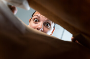 portrait of a young woman opening a paper bag