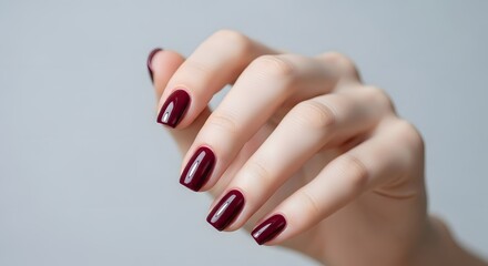 Elegant hand with burgundy manicure highlighting modern beauty trends for nail art inspiration
