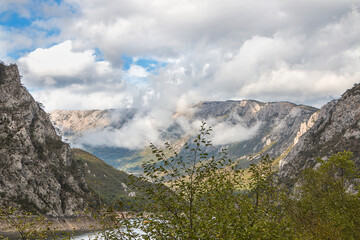 Mountains with clouds on the shore of the lake. Lake Piva in Montenegro