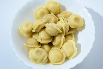 Dumplings in White Plate on Light Blue Background