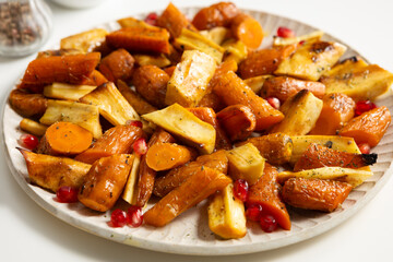 Roasted vegetables carrot parsnip roots on plate comfort food close up