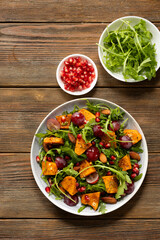 Fresh salad with pumpkin on plate wooden surface