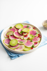 Fresh salad with sliced watermelon radish  light surface