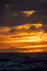 A stunning sunset reflecting golden hues on ocean waves, perfect for serene and nature-themed visuals.