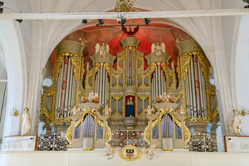 Elaborate baroque pipe organ in a historic church in Kaliningrad, Russia, featuring gold detailing, angelic statues, and a central religious painting