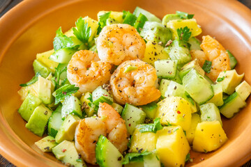 Fresh shrimp salad with mango, avocado, cucumber in lemon olive dressing