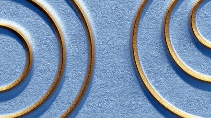 Close-up of embossed golden swirls on a textured, light blue background, creating an abstract and elegant pattern.