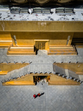 Aerial view of the striking golden Great Buddha Dordenma, its monumental stairs casting deep shadows on the stone courtyard, Thimphu, Bhutan.