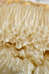 pieces and slices of ripe white grapefruit on the table, peeled ripe and juicy grapefruit pulp broken into pieces