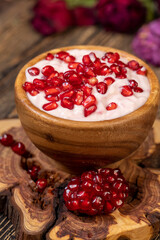 fresh pink yogurt and ripe red pomegranate seeds, delicious pomegranate-flavored yogurt and fresh ripe pomegranate