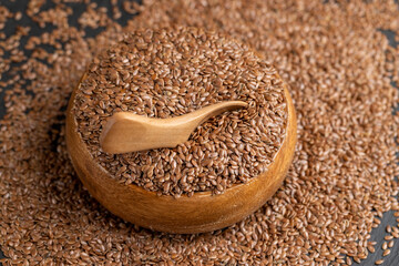flax seeds poured into a wooden bowl, a round wooden bowl completely filled with flax seeds, which can be used both for nutrition and for obtaining a new crop