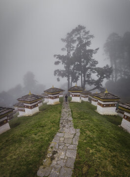 Aerial view of the Dochula Chorten's 108 memorial stupas stand in solemn contrast against the mist-shrouded hills, a spiritual haven, Hungtso, Bhutan.