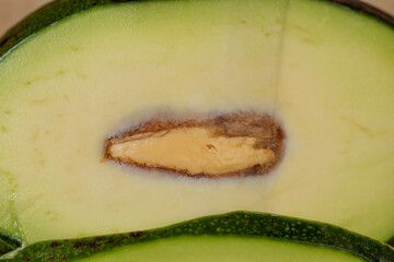 a ripe fresh avocado cut into pieces, a green avocado with soft flesh cut into pieces long ago, the seed has changed color from the air