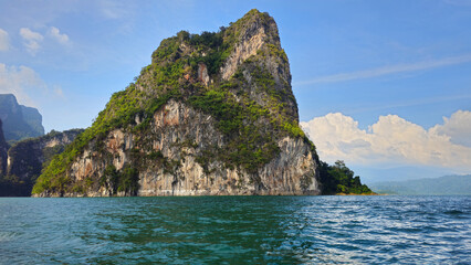 Naklejka premium Cheow Lan Lake with limestone karsts rising from tranquil water, Khao Sok National Park, Ban Ta Khun, Thailand, Southeast Asia.