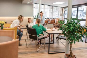 Businesswomen meeting office discussion strategy around laptop table bright environment