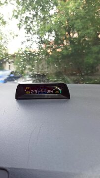 11.11.25.Moscow.Russia. TPMS auto-display on the panel. The screen shows tire pressure and temperature, raindrops on the windshield, and a yard with foliage in the background.