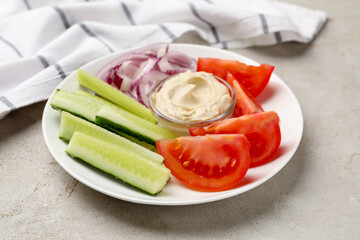 Different fresh vegetables and sauce on light grey table, closeup