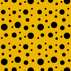 Black circles of different sizes on a yellow background.Vector seamless pattern with black circles on a yellow background.