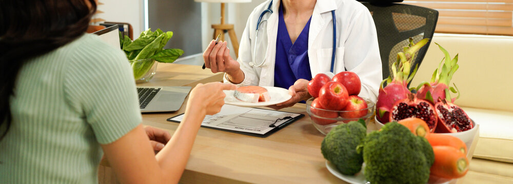 Dietician, male nutrition specialist consulting woman, developing healthy diet, dietary program. Dietary consultant asking, giving male patient advice, help, nutritional information, new meal plan