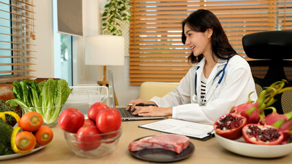professional nutritionist in uniform writing notes on the table with different healthy products and drawings on the topic of healthy eating