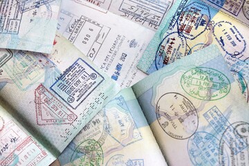 Many open passport pages with lots of visas and entrance stamps from various countries passport...
