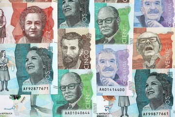 Colombian pesos money bills banknotes lies in big pile on table close up. Concept of finances and...