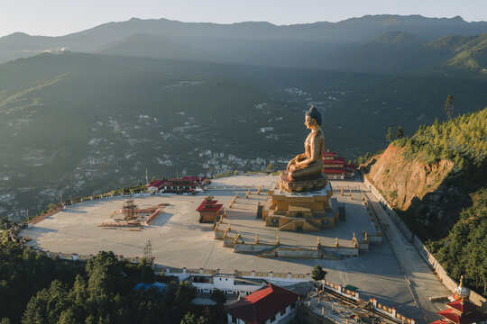 Aerial view of the golden Buddha Dordenma statue sits majestically atop a hill overlooking the valley, casting a serene glow over the landscape, Thimphu, Thimphu, Bhutan.