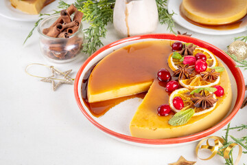 Traditional Mexican Christmas food  - caramel Eggnog Flan cake, Festive Christmas Custard Tart or Flan Topped with Caramel sauce, candied orange and cranberry, with Christmas decor copy space