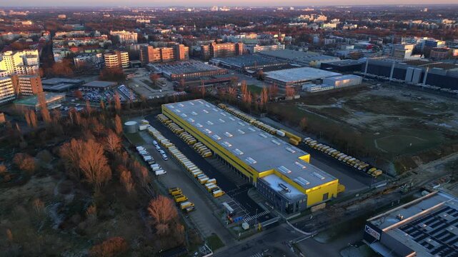 Long yellow DHL distribution center Berlin. Smooth aerial view flight drone
