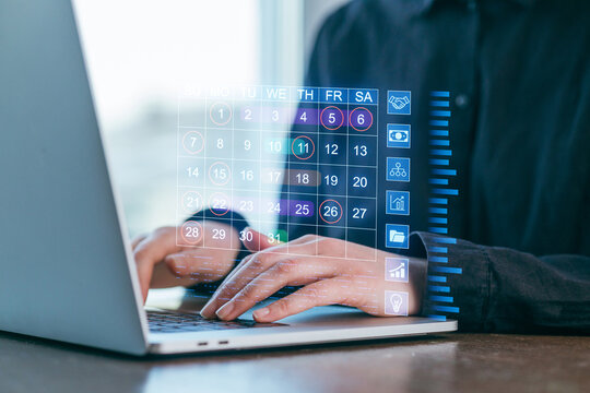 Digital calendar interface displayed while a person types on a laptop, blending technology and productivity in a modern workspace