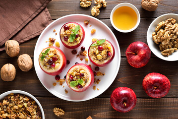 Stuffed apples with granola, cranberries, nuts and honey on plate