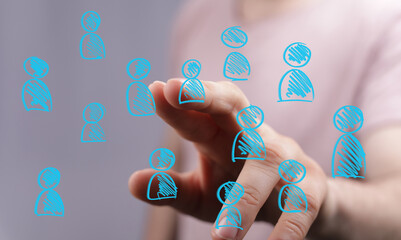 Human hand interacting with a digital display of blue hand-drawn person icons, representing social networking, global communication, and communi