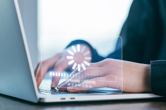 Hands typing on laptop screen during software update in a modern workspace - Powered by Adobe