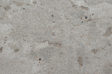 Gray concrete surface with dark speckles and subtle texture