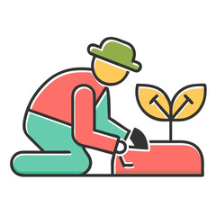 Gardener planting a small seedling in a raised garden bed