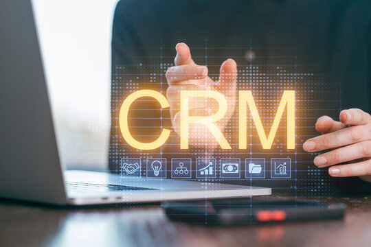 Person interacts with virtual CRM interface on laptop in a modern workspace during daytime