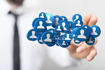 Close-up of a hand holding a network of people icons, representing connections, social media and...