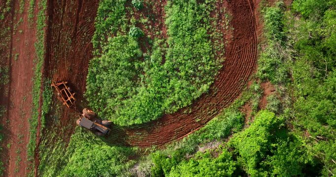 Tractor with agricultural implement plowing land next to riparian forest