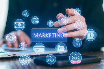 Hands working on a laptop with digital marketing icons displayed on the screen during a business meeting in a modern office