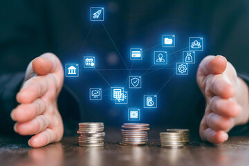 Hands protecting stacks of coins with digital icons representing finance and technology in a modern setting