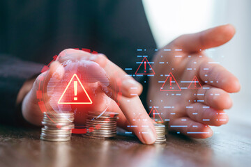 Coins are stacked while digital alerts signal potential financial risks and concerns at a desk