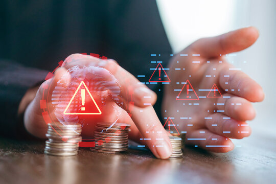 Coins are stacked while digital alerts signal potential financial risks and concerns at a desk
