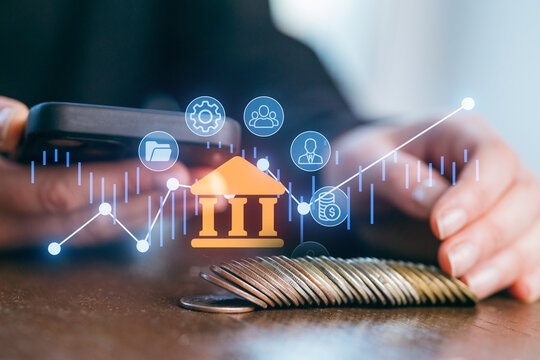 Mobile banking transactions with digital graphs and finance icons on a wooden table