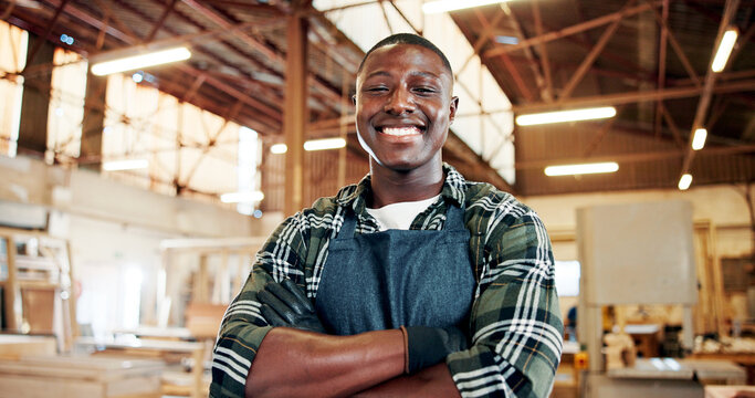 Carpentry, entrepreneur and man with arms crossed, portrait and workshop for production and woodwork. Confident, artisan and black person with smile in warehouse, manufacturing and career development
