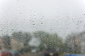Raindrops on Car Window with Blurred Street Background on a Rainy Day