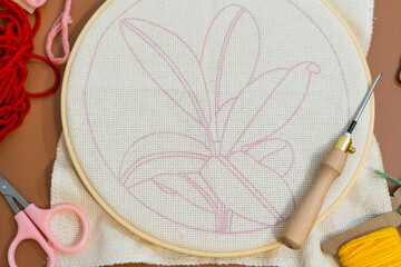 Crafting a floral embroidery design with colorful threads and tools on a workspace. punch needle craft